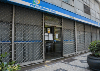 Agência da Previdência Social (INSS) com portas fechadas e grades, indicando não funcionamento em dia útil