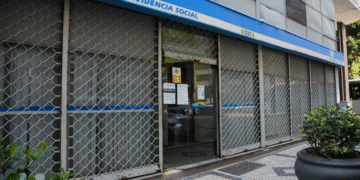 Agência da Previdência Social (INSS) com portas fechadas e grades, indicando não funcionamento em dia útil