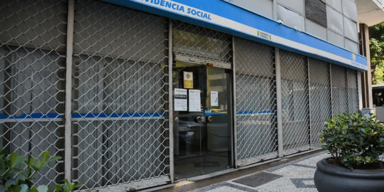 Agência da Previdência Social (INSS) com portas fechadas e grades, indicando não funcionamento em dia útil