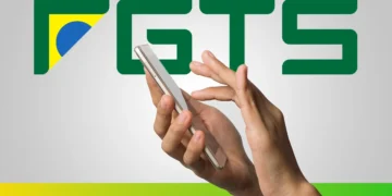 Mãos utilizando smartphone para consultar saldo do FGTS com símbolo do FGTS ao fundo