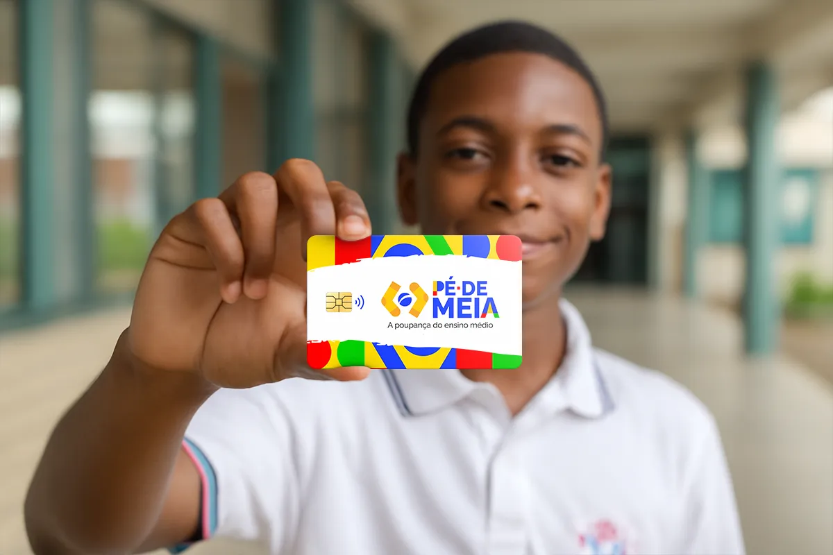 Estudante do ensino médio de escola pública mostrando o cartão do programa Pé-de-Meia, simbolizando o cumprimento dos requisitos de frequência e matrícula para receber o benefício.