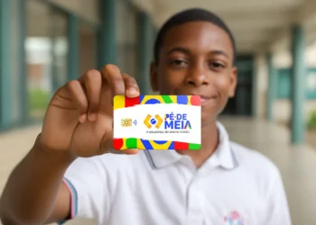 Estudante de ensino médio sorrindo e exibindo o cartão de benefício do programa Pé-de-Meia, que oferece poupança e incentivo financeiro para a conclusão escolar.
