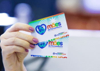 Mão segurando dois cartões do programa Mães de Pernambuco.