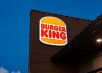 Fachada noturna do drive-thru do Burger King com o logotipo aceso, remetendo à promoção "Bole-Thru: A Vingança dos Boletos" de Halloween.