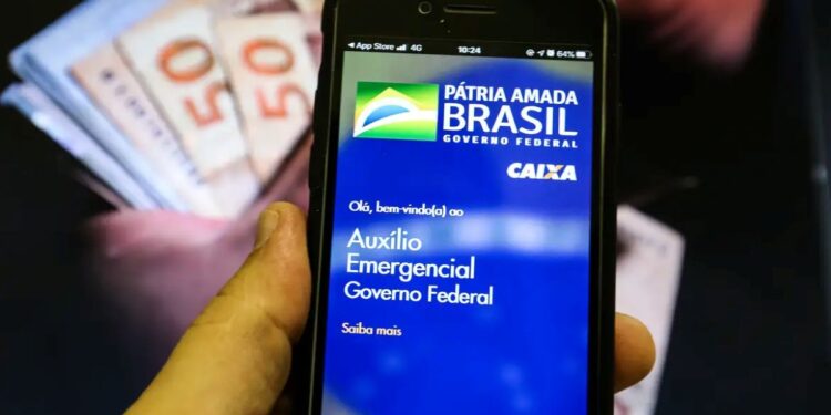 Aplicativo Auxílio Emergencial em smartphone com notas de dinheiro desfocadas ao fundo, representando a notificação para devolução.