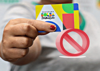 Cartão do Programa Bolsa Família sendo segurado por uma mão, com um símbolo de proibição sobreposto.