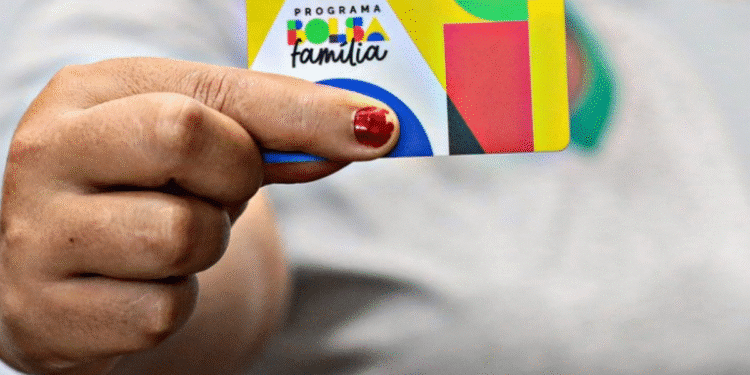 Cartão do programa Bolsa Família sendo segurado por uma pessoa.