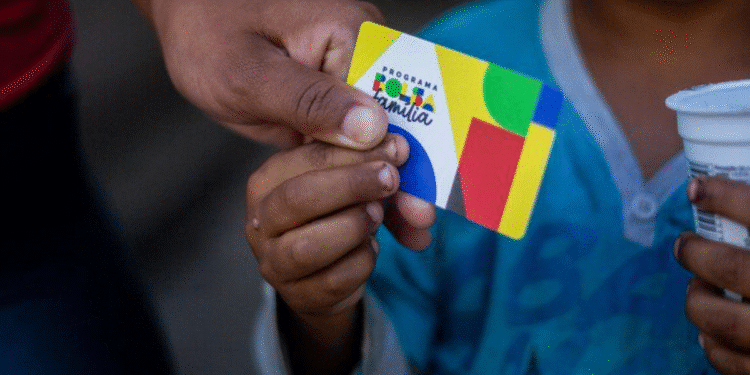 Cartão do Bolsa Família sendo segurado por uma criança