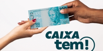 Duas mãos trocando uma nota de 100 reais com o logo do Caixa Tem ao lado.