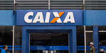 Fachada de agência da Caixa Econômica Federal com pessoas passando em frente.