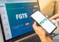 Pessoa acessando informações do FGTS pelo celular e computador.