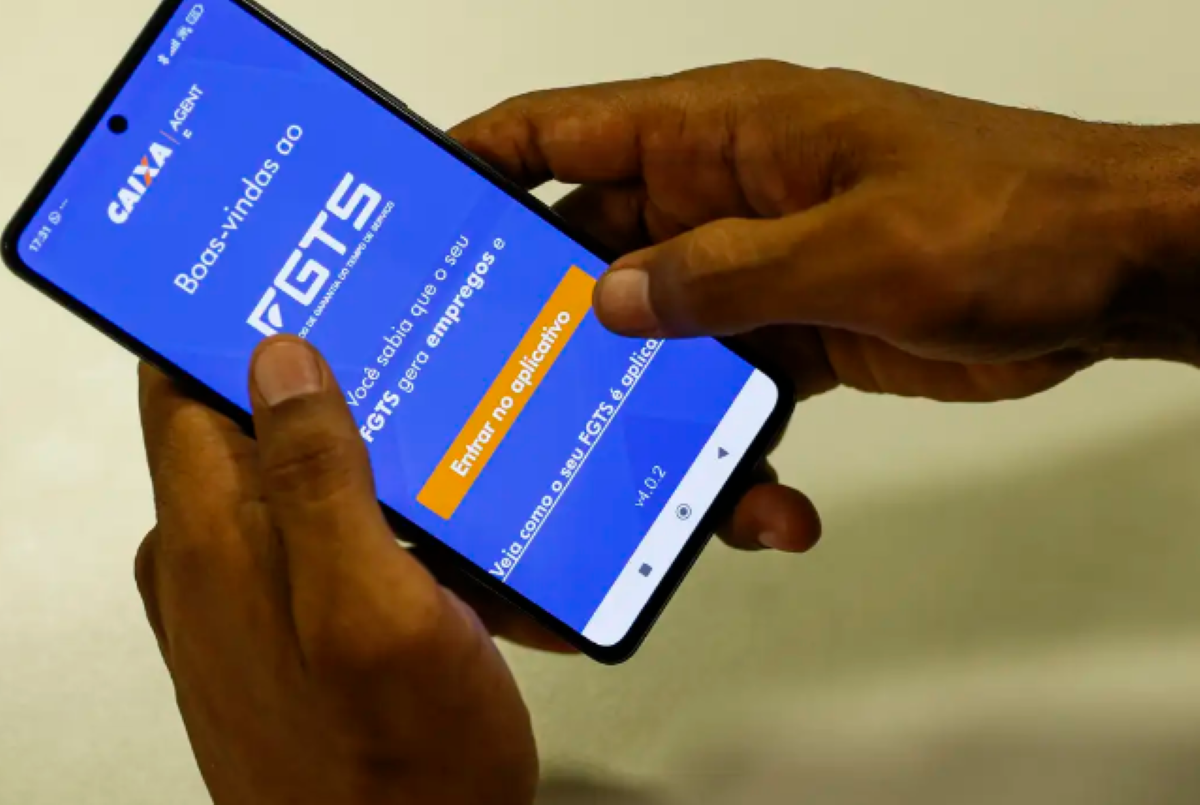 Aproveite o crédito do FGTS antes das novas regras Pessoa acessa o aplicativo do FGTS no celular, com a tela de boas-vindas exibida.