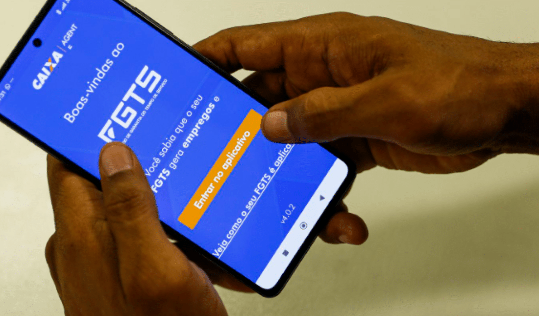 Pessoa acessando o aplicativo do FGTS no celular.