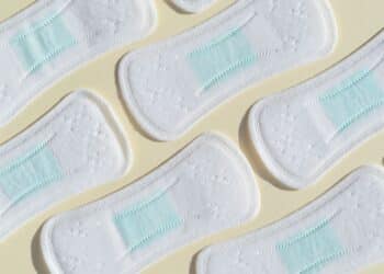Absorventes higiênicos dispostos lado a lado, representando a distribuição gratuita do kit pelo Programa Dignidade Menstrual do SUS, mediante cadastro no CadÚnico.