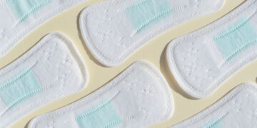 Absorventes higiênicos dispostos lado a lado, representando a distribuição gratuita do kit pelo Programa Dignidade Menstrual do SUS, mediante cadastro no CadÚnico.