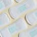 Absorventes higiênicos dispostos lado a lado, representando a distribuição gratuita do kit pelo Programa Dignidade Menstrual do SUS, mediante cadastro no CadÚnico.