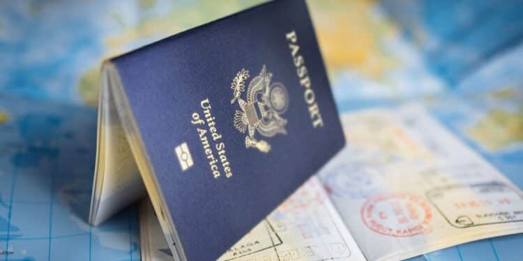 Passaporte americano aberto com carimbos de vistos sobre um mapa, simbolizando o processo de solicitação de visto para os EUA.