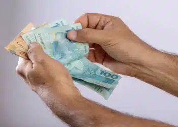 Saque calamidade do FGTS: veja quem pode solicitar o dinheiro a partir desta quarta-feira (14/10) 6 Mãos de uma pessoa contando cédulas de reais, ilustrando a liberação do Saque Calamidade do FGTS