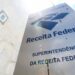 Placa com o logo da Receita Federal, alertando sobre a veracidade de mensagens e comunicações oficiais.