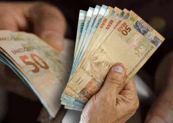 Dinheiro em notas de reais representando o novo salário mínimo previsto para 2026