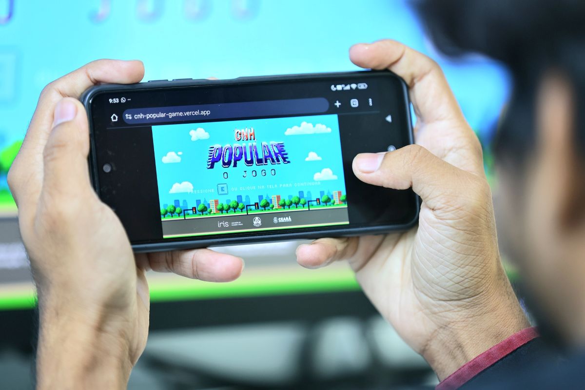 Homem jogando o jogo da CNH Popular no celular, ilustrando a preparação para a obtenção da carteira de motorista