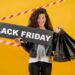 Mulher feliz com placa "Black Friday" e sacolas, representando compras e a importância dos direitos do consumidor.