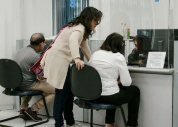 Pessoas sendo atendidas em balcões do INSS, representando a disponibilidade de vagas para atendimento no fim de semana em Minas Gerais.