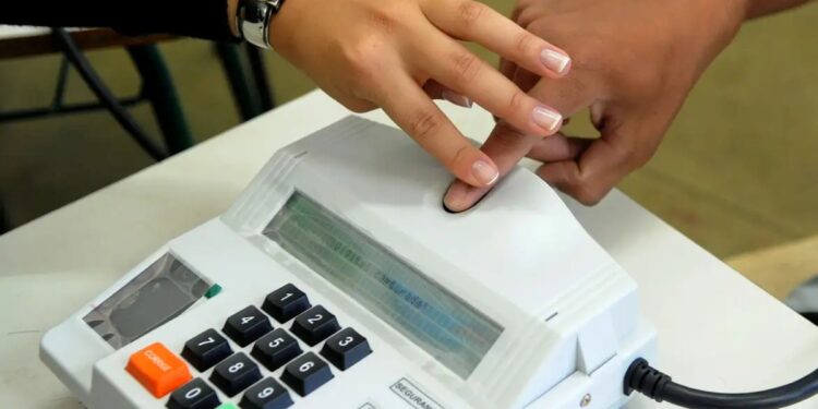 Pessoa realizando coleta de biometria digital em equipamento oficial durante o cadastramento para benefícios do INSS.