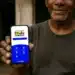 Homem segurando celular com tela do aplicativo Bolsa Família exibindo opções e acesso