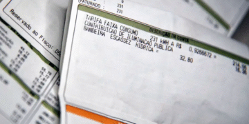 Contas de luz em close-up, mostrando detalhes de consumo e tarifas, ilustrando o aumento da conta de luz em novembro.