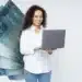 Mulher sorridente com notebook e notas de 100 reais ao fundo, representando a gestão do 13º salário.
