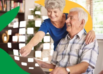 Casal de idosos consultando um computador, representando a facilidade de acesso ao aplicativo Meu INSS para verificar a restituição de descontos indevidos.