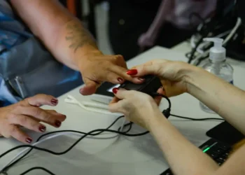 Mãos femininas colocando a digital para realizar biometria