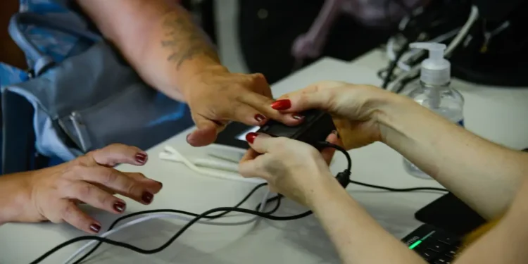 Mãos femininas colocando a digital para realizar biometria