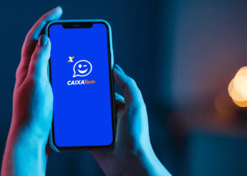 Pessoa segurando celular com a tela exibindo o aplicativo CAIXA Tem.