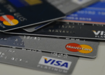 Vários cartões de crédito das bandeiras Visa e Mastercard empilhados.