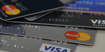 Vários cartões de crédito das bandeiras Visa e Mastercard empilhados.