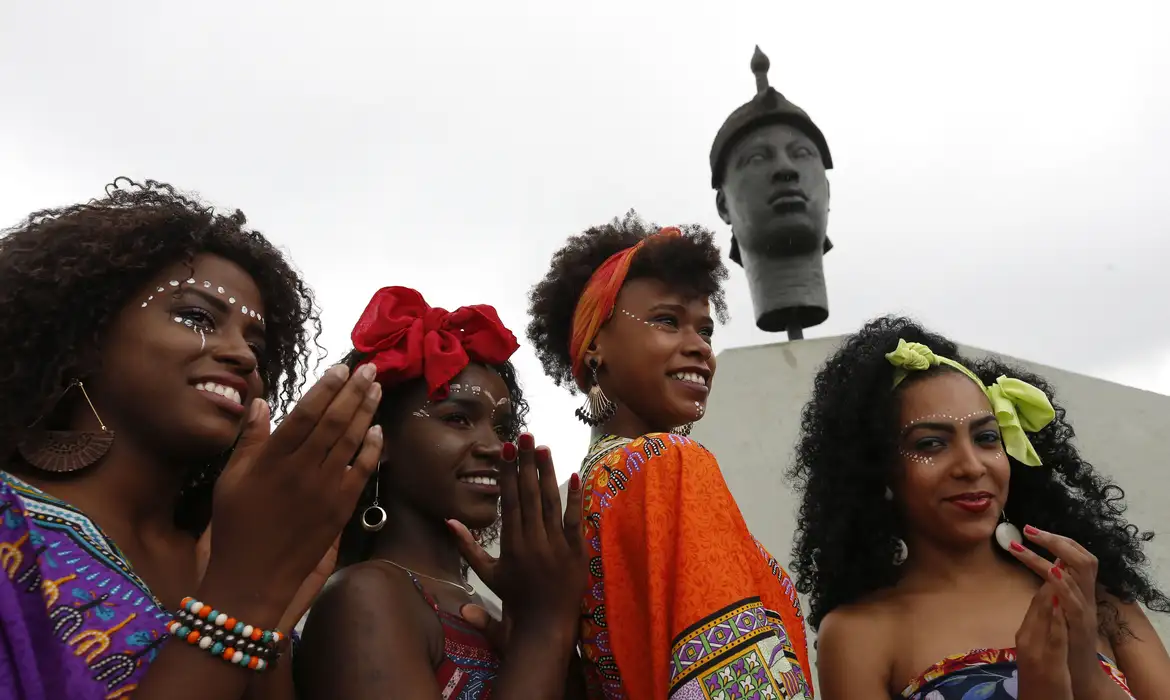 Regras da CLT: O que o Artigo 70 Determina Sobre o Trabalho e as Exceções em Feriados Nacionais (como 20 de Novembro) Celebração do Dia da Consciência Negra, com mulheres sorridentes e adereços culturais, simbolizando o feriado de 20 de novembro regido pela CLT.