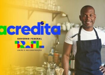 Empreendedor sorridente em seu negócio, ao lado do logo "Acredita Governo Federal Brasil", simbolizando a oportunidade para quem está no Cadastro Único.