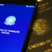 Smartphone exibindo o aplicativo Carteira de Trabalho Digital ao lado da Carteira de Trabalho e Previdência Social física.