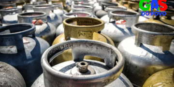 Muitos botijões de gás de 13 kg empilhados com logo do Gás do Povo, ilustrando recarga grátis pelo programa.