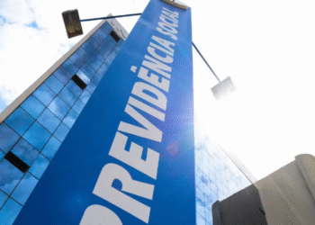 Fachada de prédio do INSS com placa azul escrito “Previdência Social”.