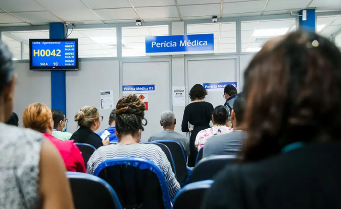 INSS abre 220 vagas de perícia extraordinária para agilizar benefícios Pessoas aguardando atendimento em sala de perícia médica do INSS