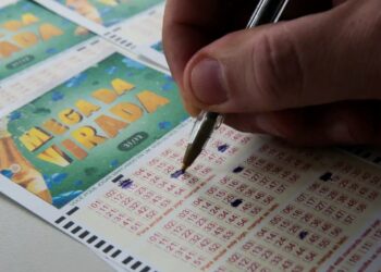 Cartão de aposta da Mega da Virada 2025 sendo preenchido com uma caneta