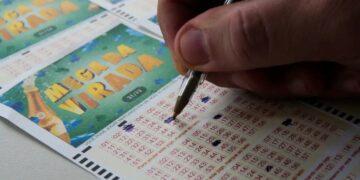 Cartão de aposta da Mega da Virada 2025 sendo preenchido com uma caneta