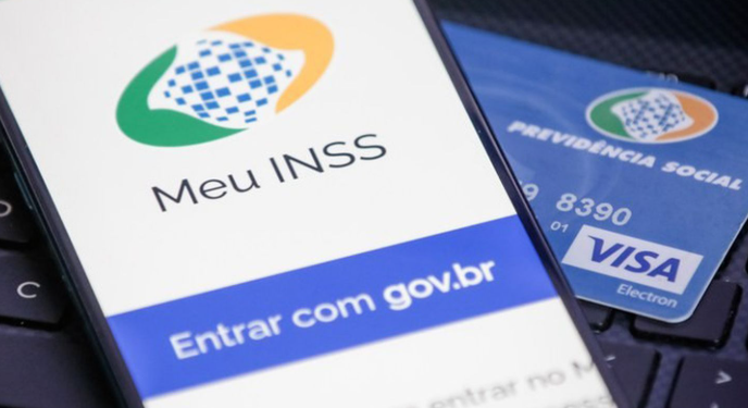 INSS não pode cortar benefício sem aviso Tela do aplicativo Meu INSS em celular ao lado de cartão da Previdência Social.