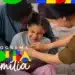 Pai, mãe e filha pequena sorrindo e se abraçando em um momento de carinho, com o logotipo colorido do Programa Bolsa Família aplicado no canto inferior esquerdo.