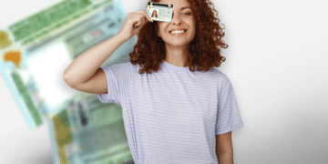 Mulher sorridente segurando CNH digital diante de documentos brasileiros desfocados