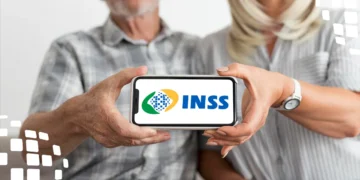 Casal de idosos consultando um aplicativo de celular com a logo do INSS. A imagem ilustra o mutirão com 840 vagas para agendamento de perícia médica e benefícios.