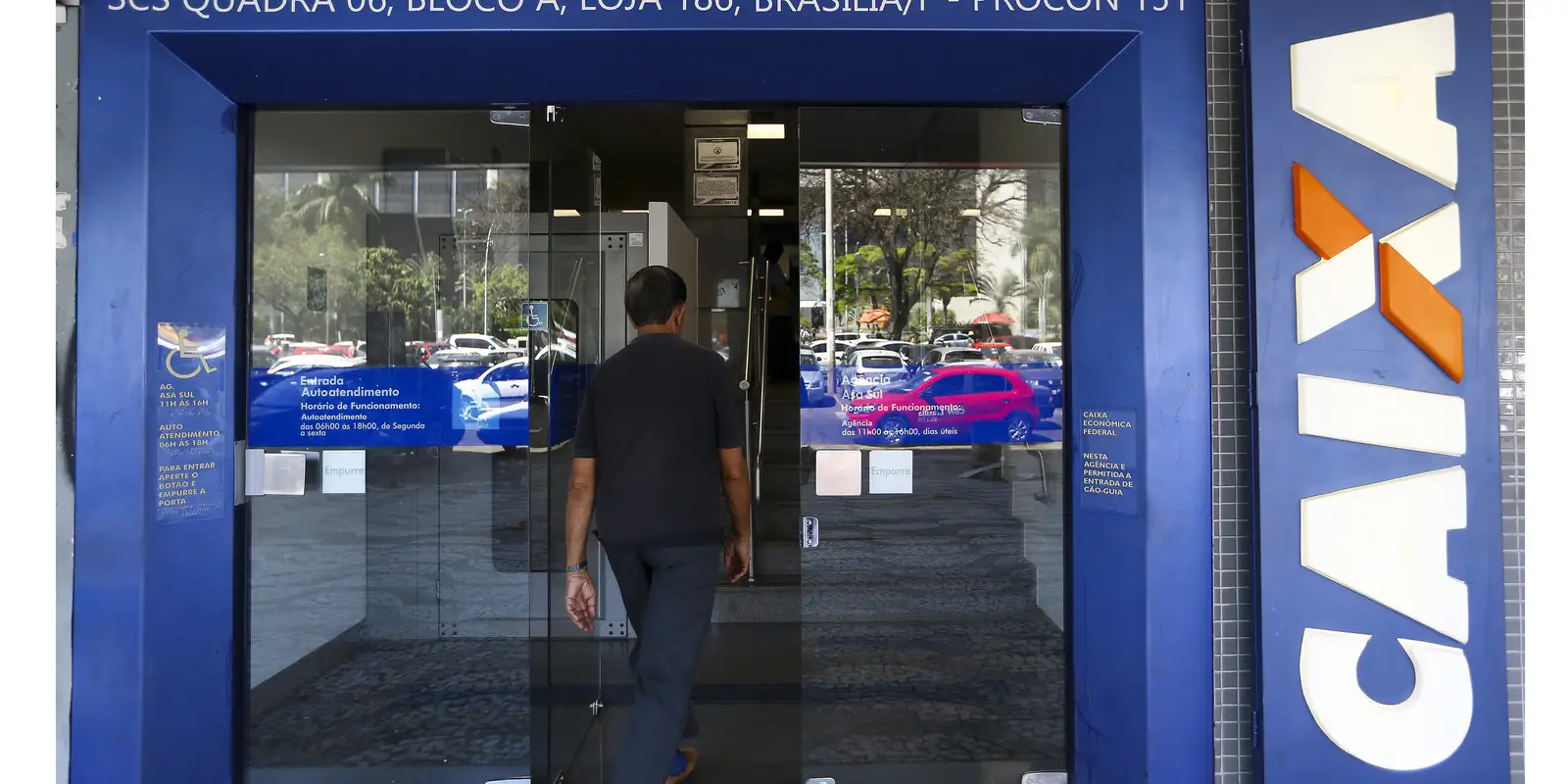 Funcionamento dos bancos no Natal e no Ano Novo. Cliente entra em agência bancária da Caixa Econômica Federal durante período de funcionamento especial no fim de ano.